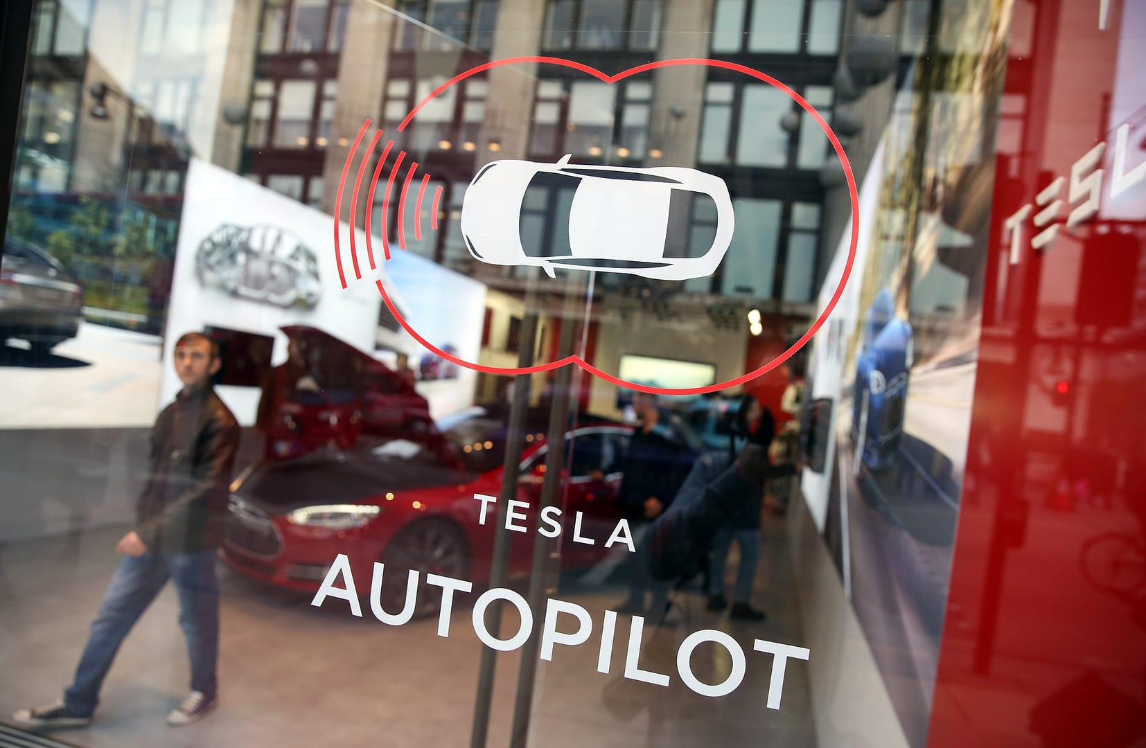 A decal advertising Tesla Motors Inc.'s Autopilot feature sits on a window of their showroom at a dealership, on Oxford Street in London, U.K., on Wednesday, Dec. 16, 2015. After losing $1.88 billion since 2007, Tesla is piling on the personnel as it offers more models, builds the worlds biggest battery factory and expands globally, including stores opening in Mexico City and Edinburgh.