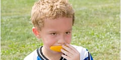 kid eating orange