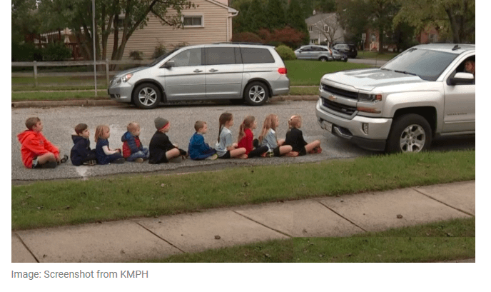 children seating on sidewalk