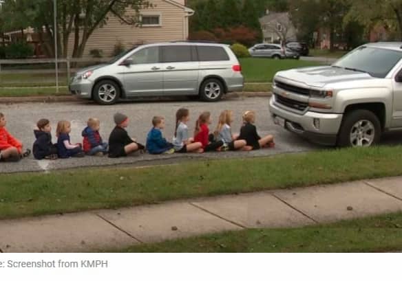 children seating on sidewalk